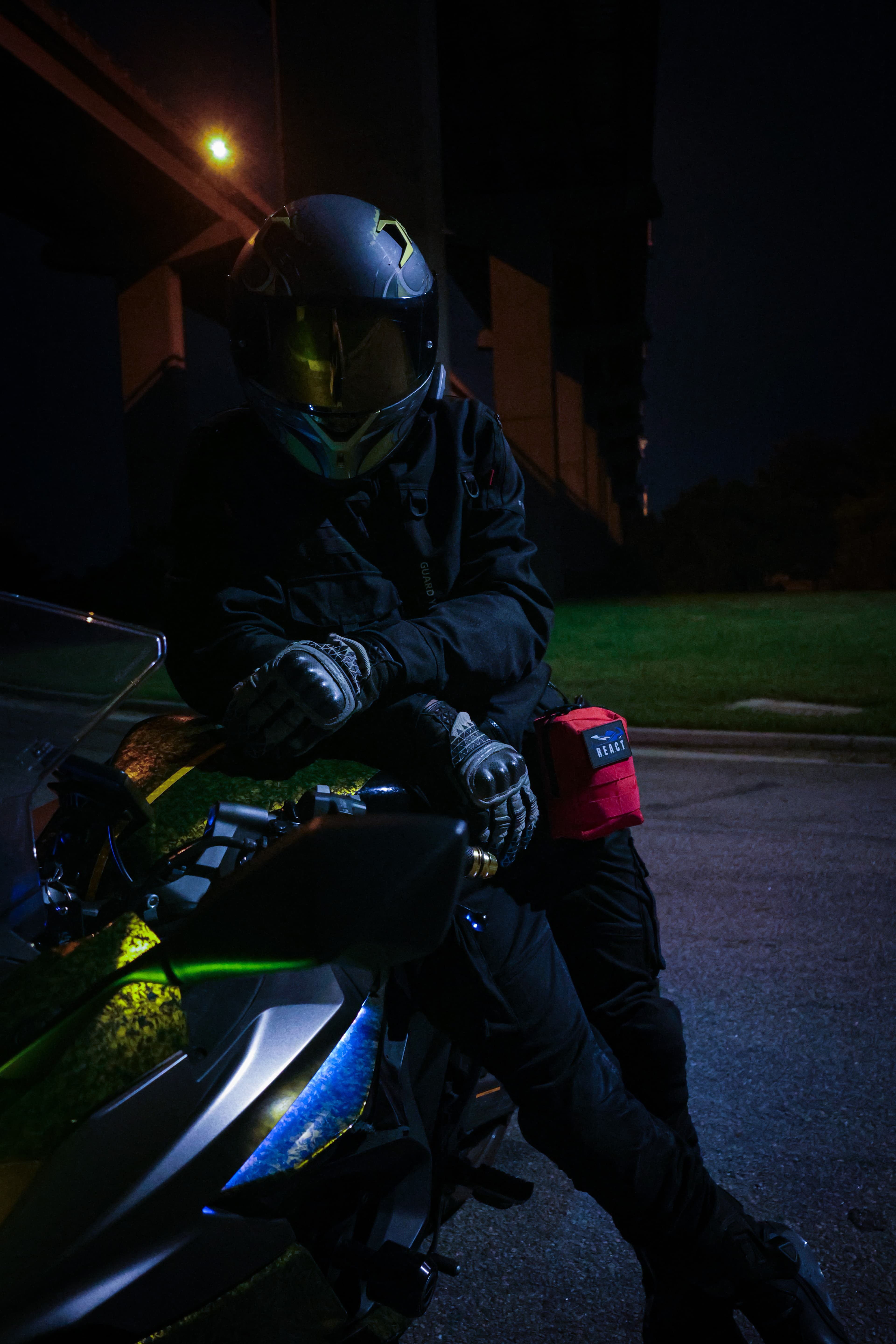 Rider with the R.E.A.C.T. Trauma Kit mounted on their bike at night